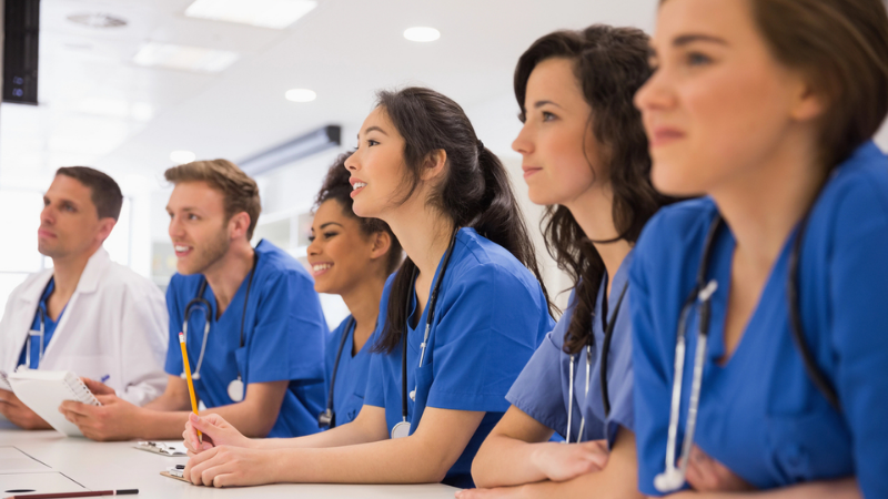 Alunos de medicina sentados à mesa de faculdade